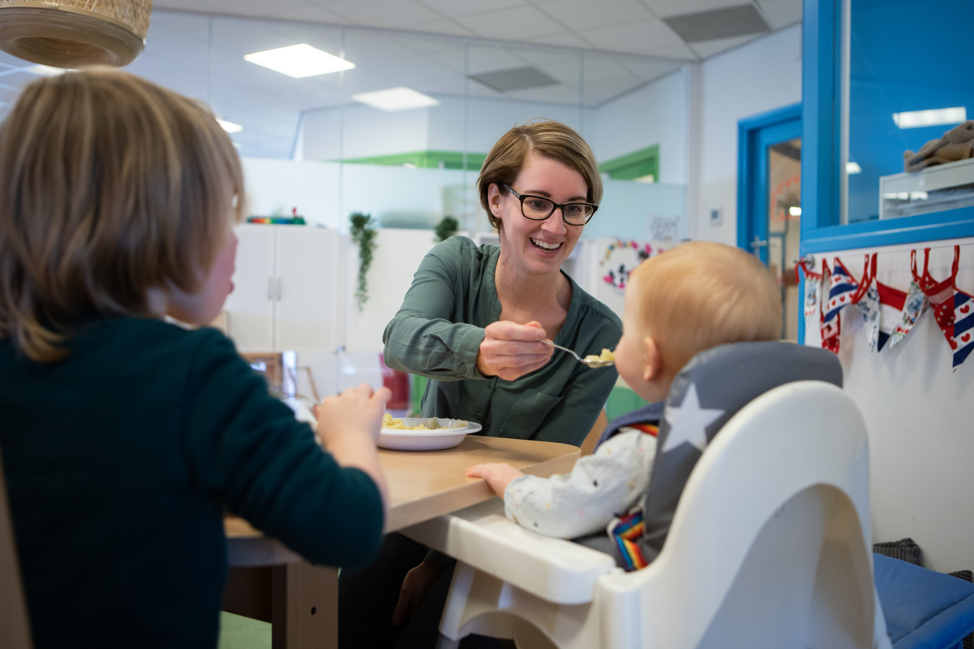 pedagogisch medewerker geeft kind eten