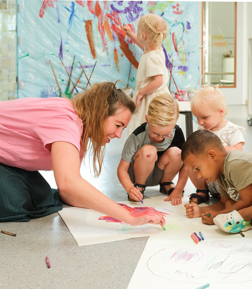 Pedagogisch professional Lillian is aan het knutselen met de kinderen