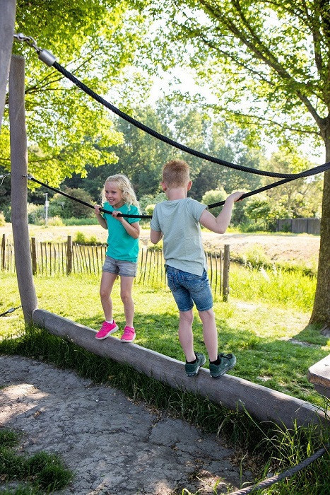 jongen en meisje houden evenwicht op balk
