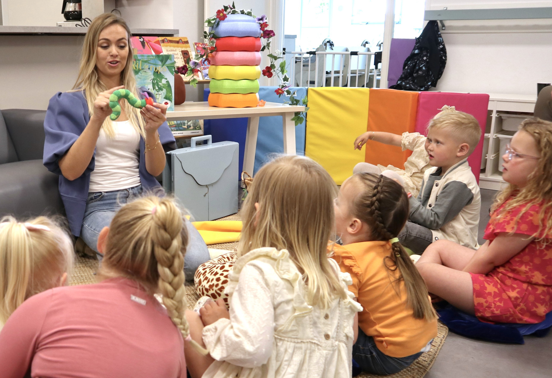 medewerker vertelt verhaal aan kinderen