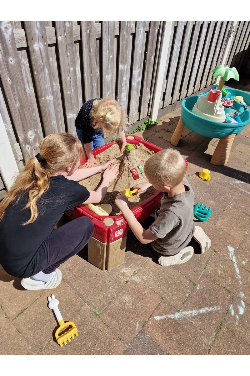 kinderen zijn bij zandtafel aan het spelen