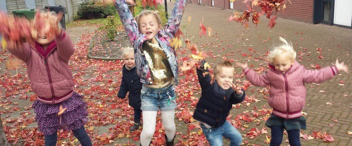 kinderen gooien met rode bladeren
