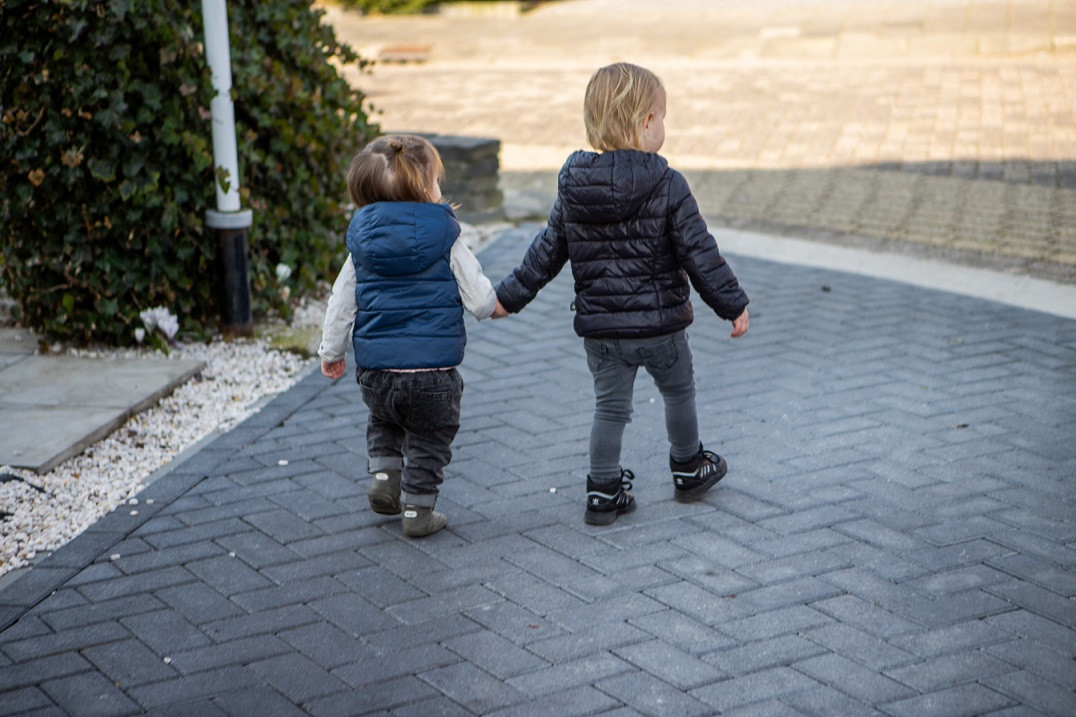 twee kinderen lopen hand in hand