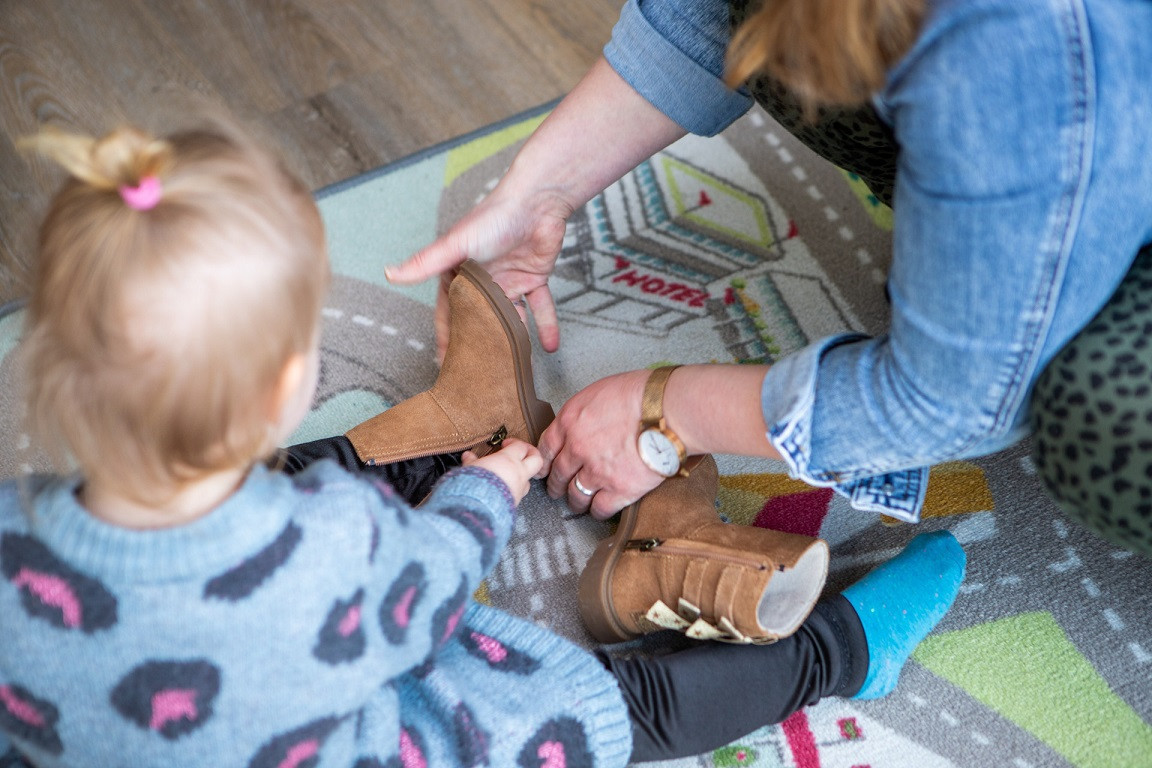 peuter trekt schoenen aan