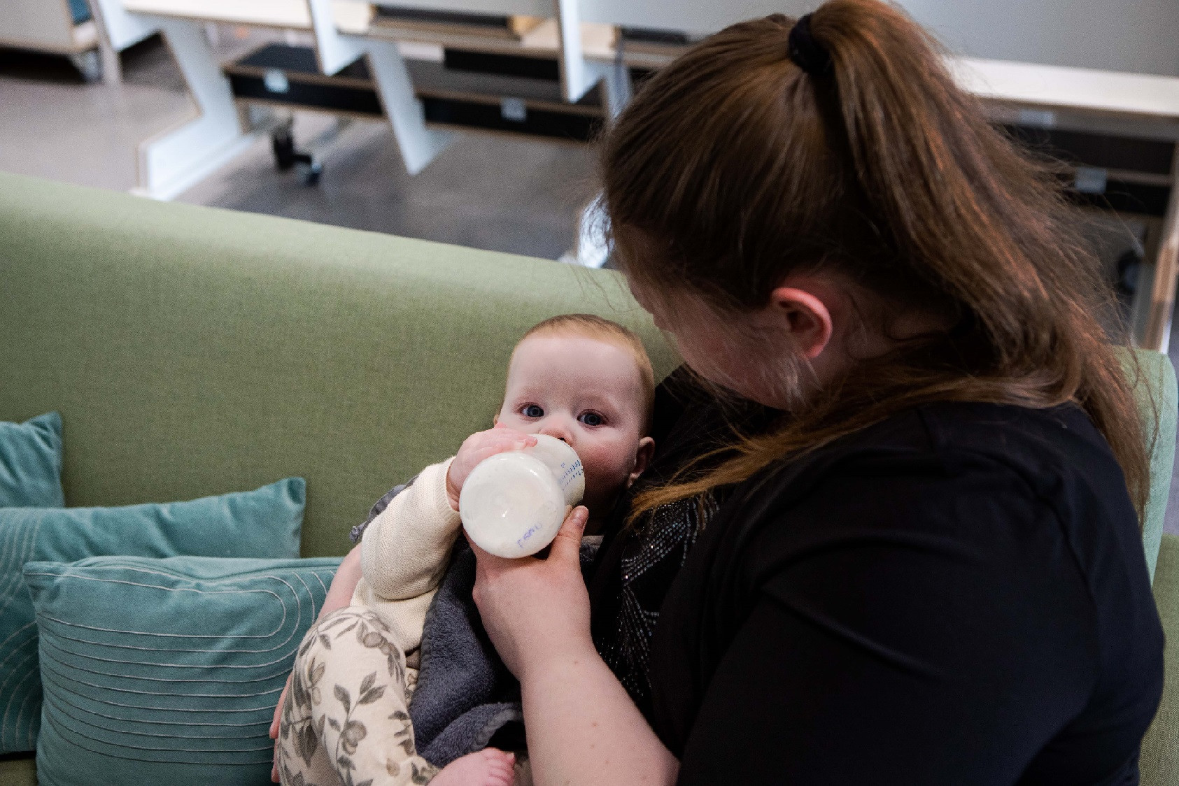pedagogisch professional geeft baby fles