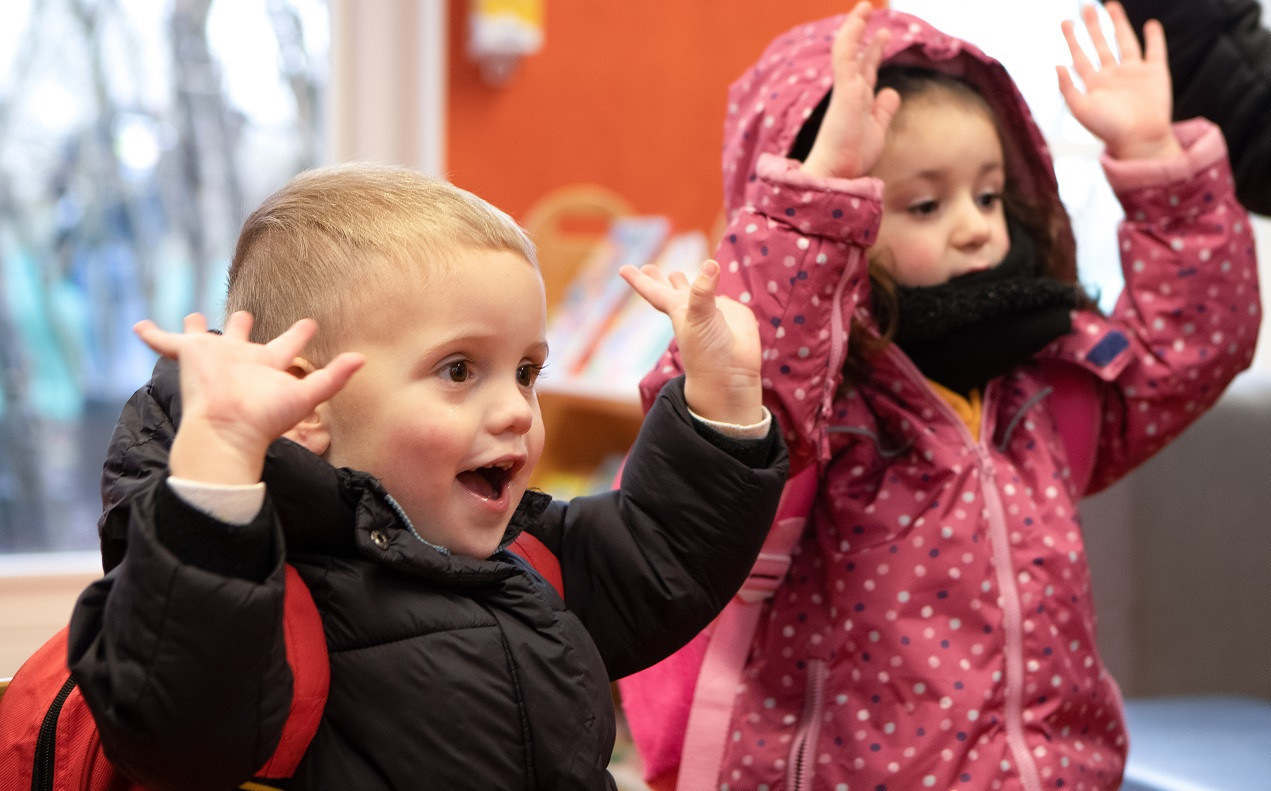 twee kinderen houden handen in lucht