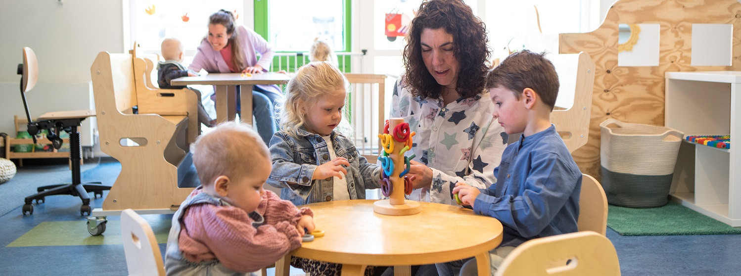 pedagogisch professional met kinderen aan tafel