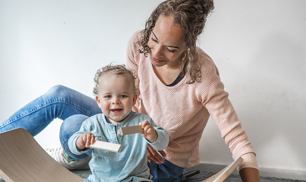 Pedagogisch professional met kind op grond