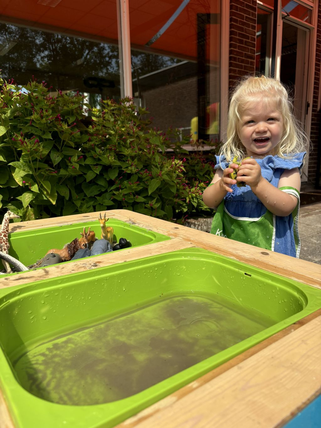 meisje speelt met speelgoed dieren in water