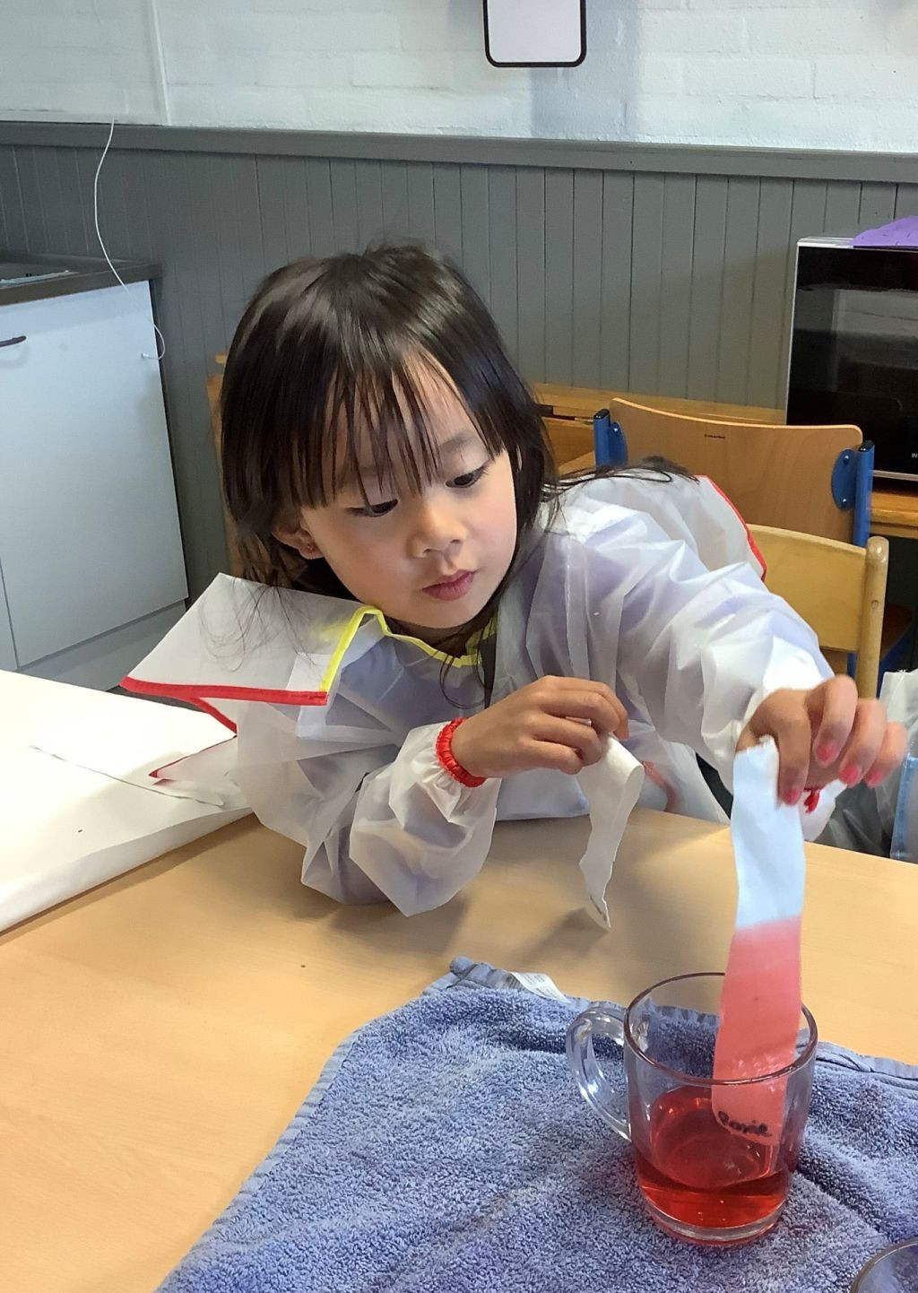 Kind doet proefje met papier en gekleurd water