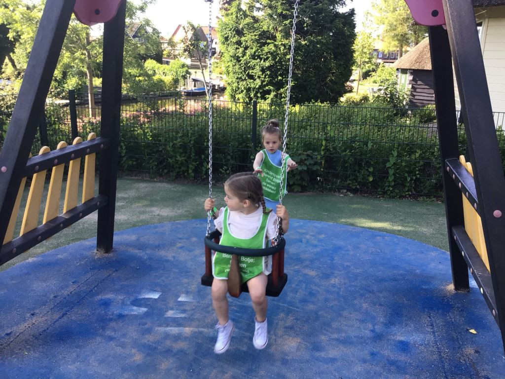 peuter zit op schommel