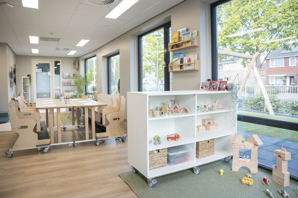 Tafel en speelhoek in de binnenruimte van kinderdagverblijf meridiaan in Medemblik