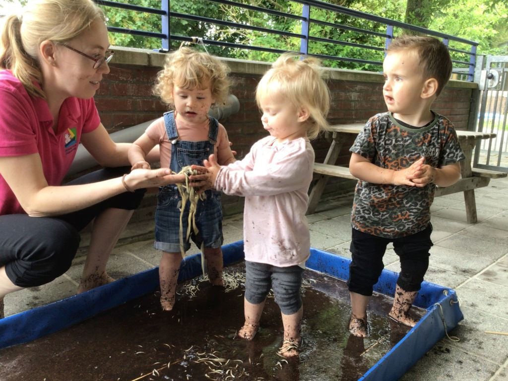 kinderen staan in modderbadje