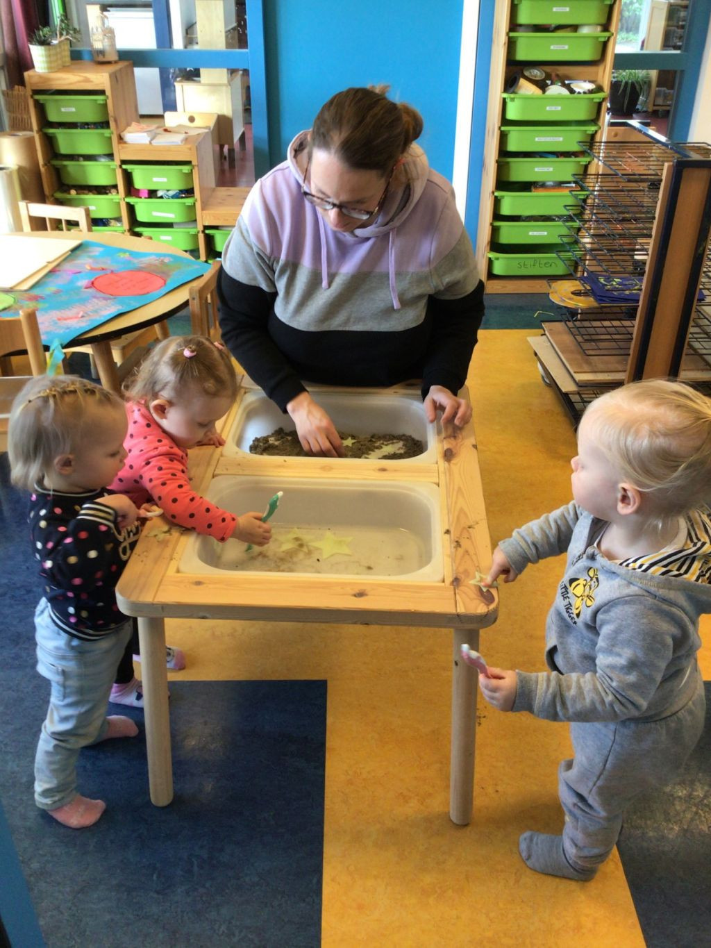 peuters spelen met water en zandbak