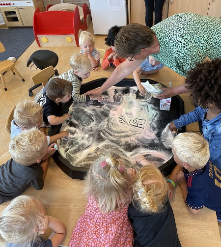 peuters maken kunst in zand