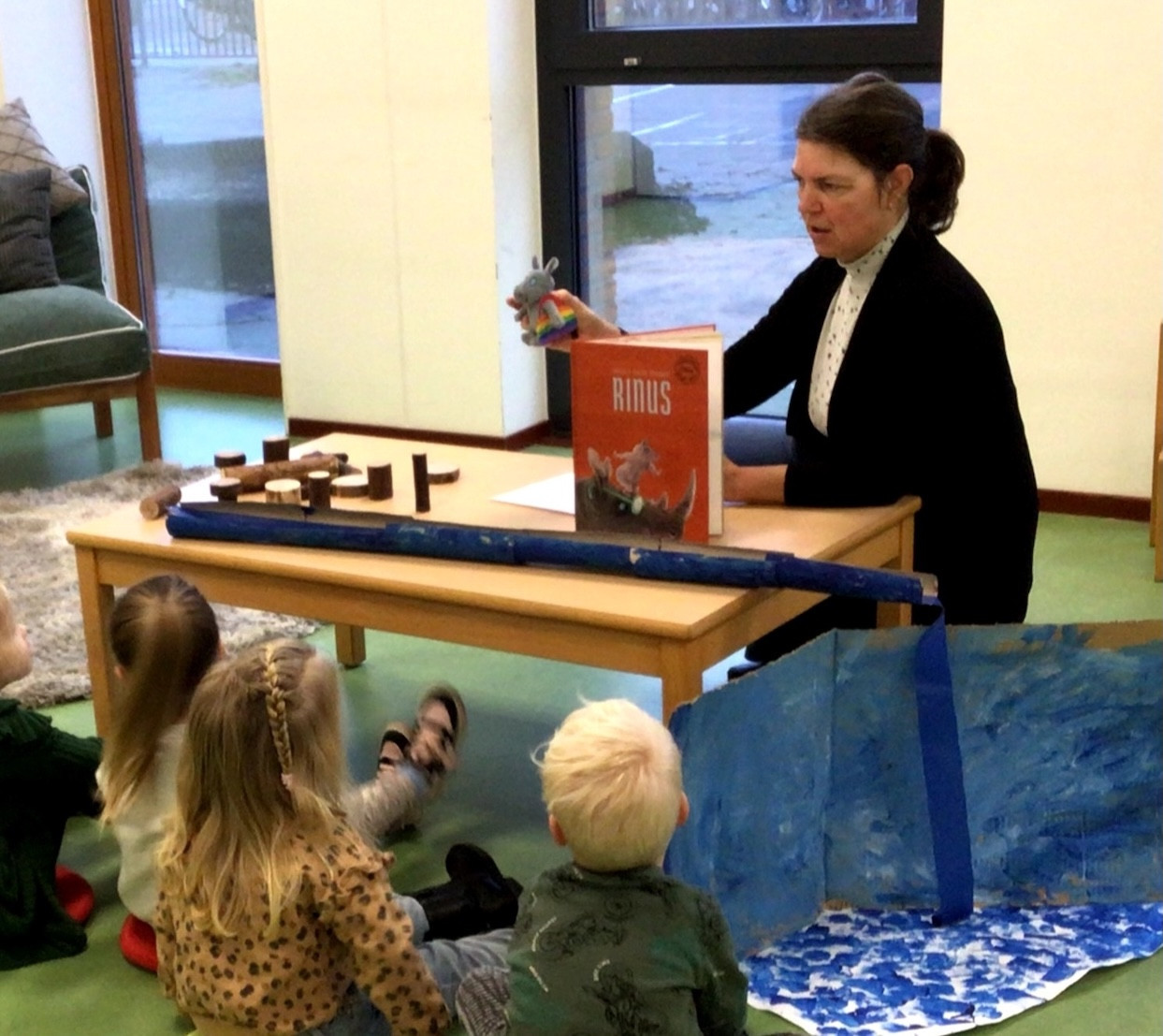 Pedagogisch professional leest een boek voor aan peuters