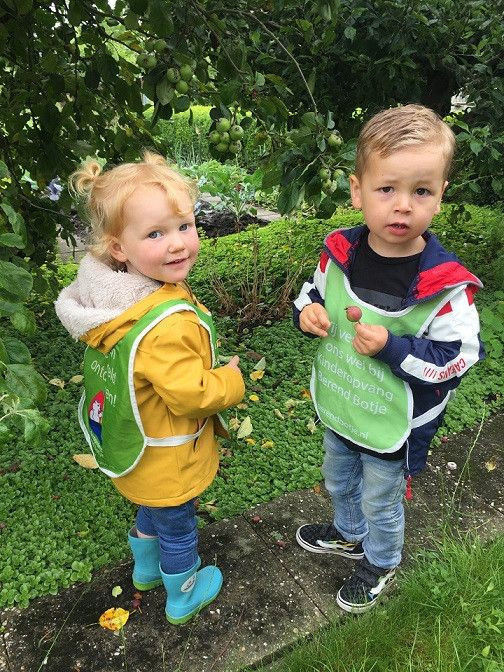twee kinderen met berend botje hesje aan in de moestuin