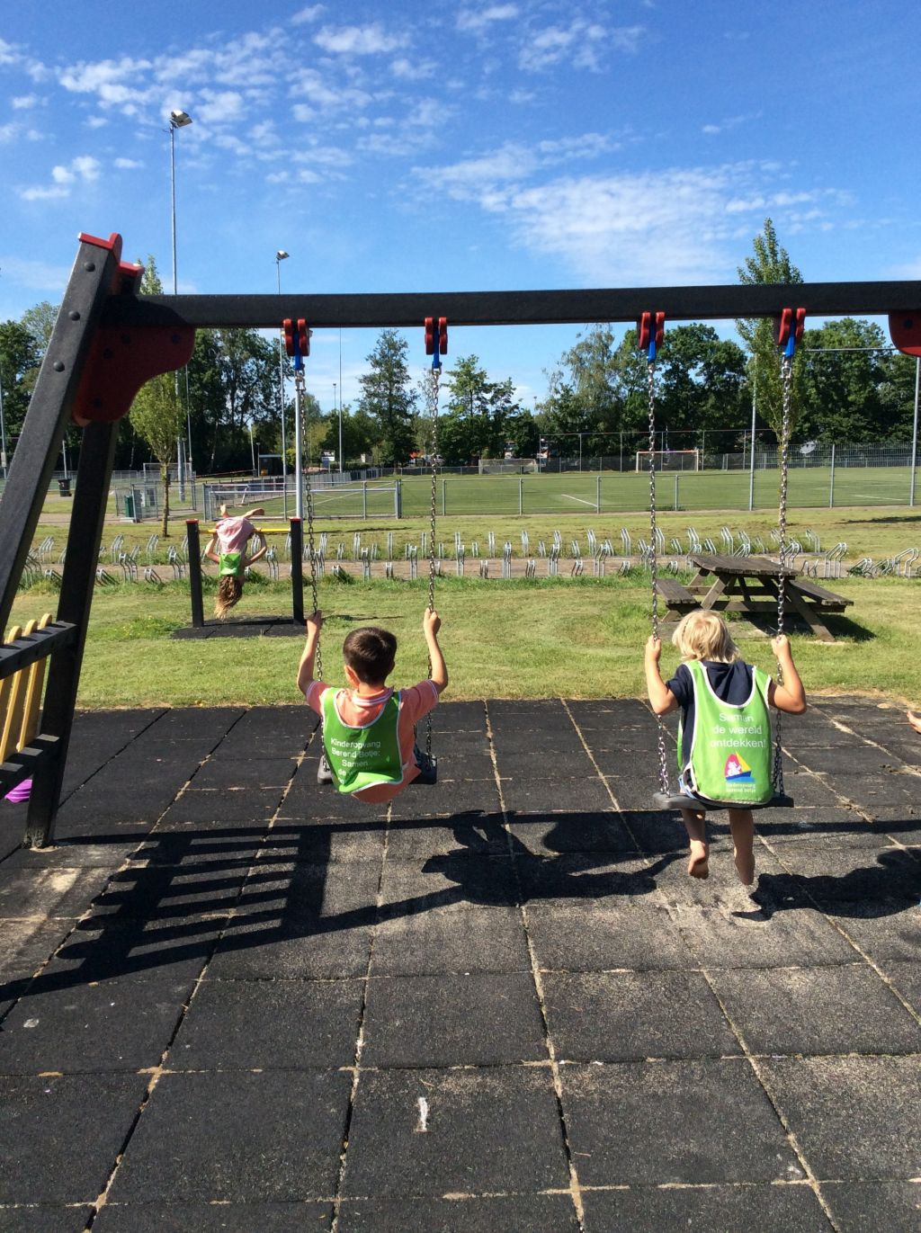 kinderen in speeltuin op schommel