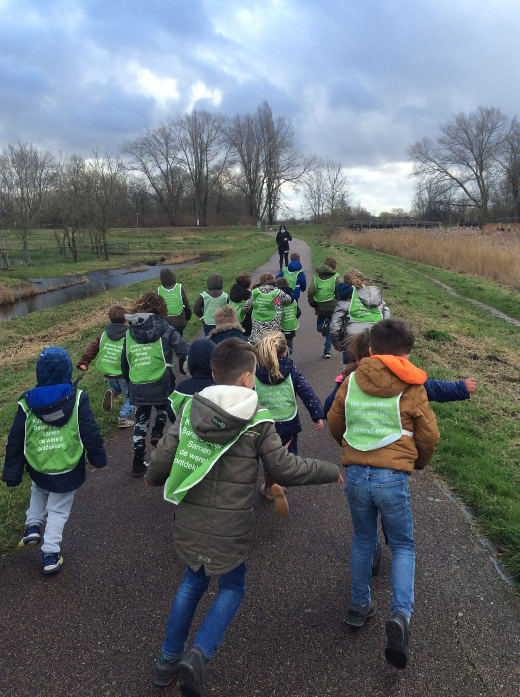 groep kinderen rennen met berend botje hesjes aan