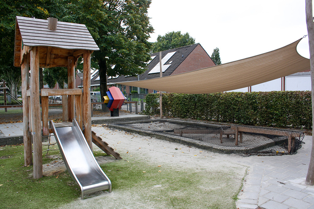 Glijbaan en zandbak op speelplein