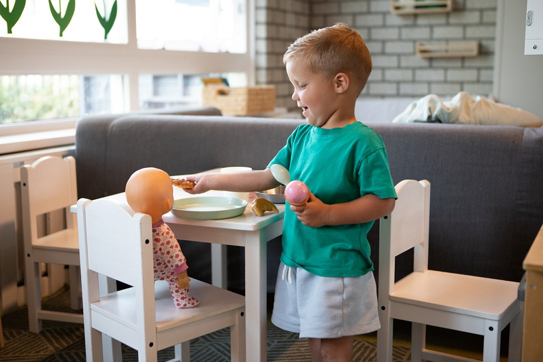 jongen geeft pop eten