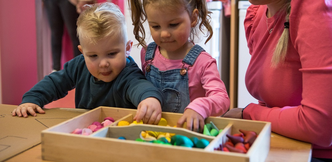 kinderen pakken speelgoed uit bak