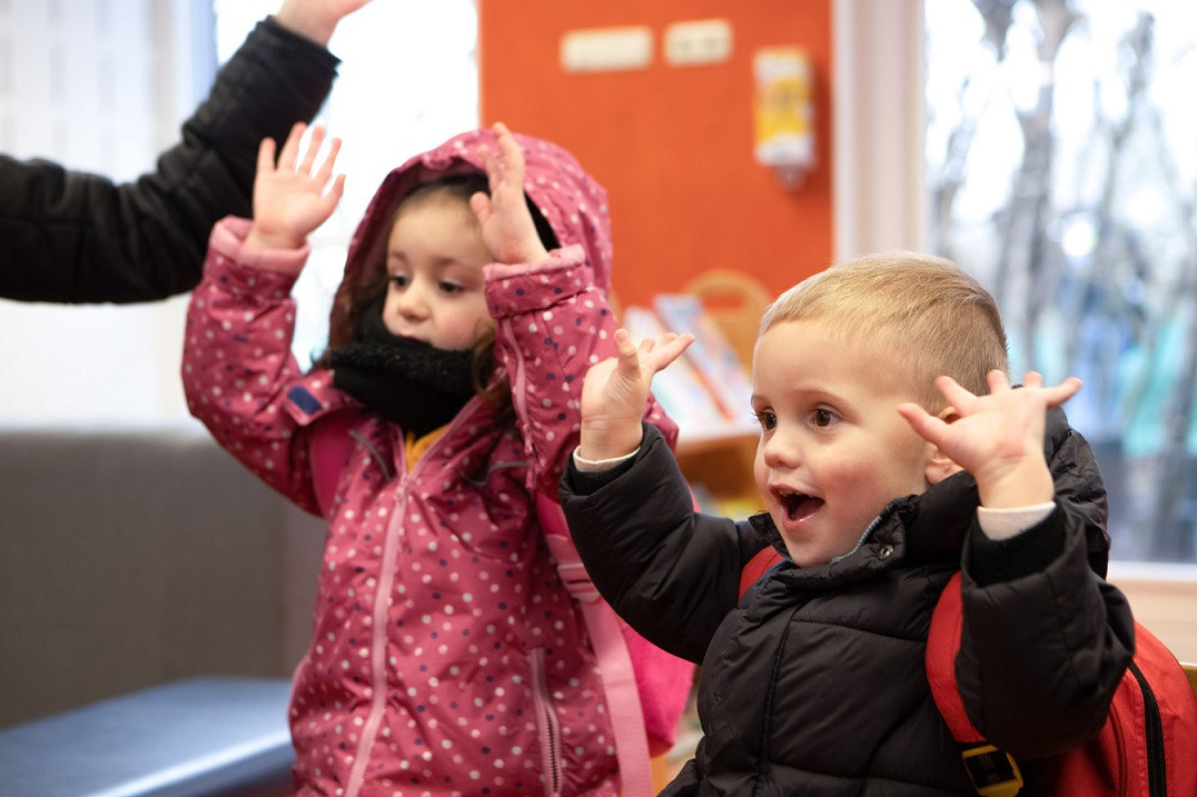 kinderen doen handen in lucht