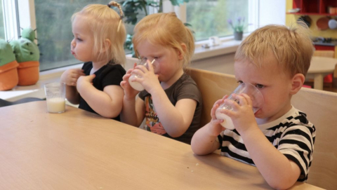 Kinderen drinken glaasje melk aan tafel