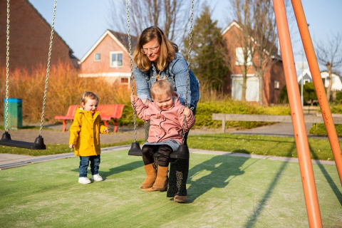 gastouder helpt kind op schommel