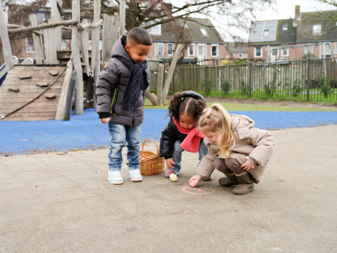Kinderen tekenen met paaskrijt