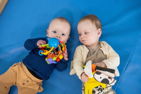 twee baby's pelen samen op de grond