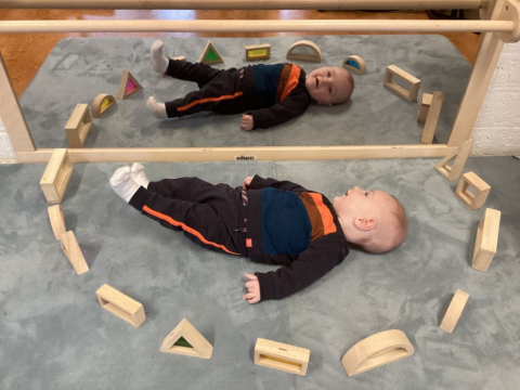 kind speelt met houten blokken bij een spiegel