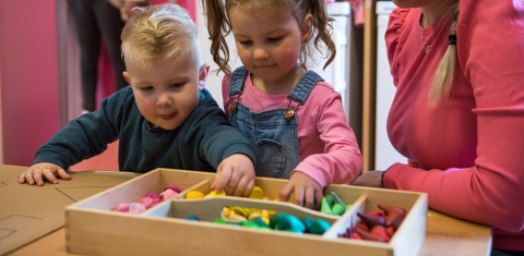 kinderen pakken speelgoed uit bak