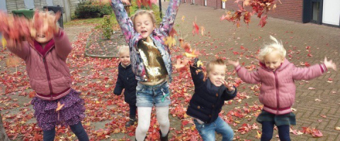 kinderen gooien met rode bladeren
