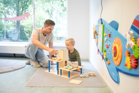 pedagogisch medewerker speelt samen met peuter