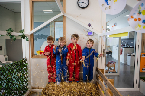 kinderen in overalls die gooien met hooi