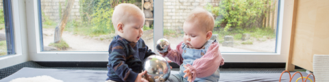 foto van twee baby's die aan het spelen zijn