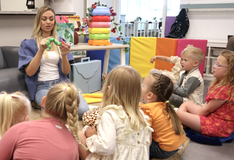 medewerker vertelt verhaal aan kinderen