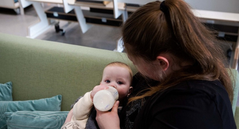 pedagogisch professional geeft baby de fles