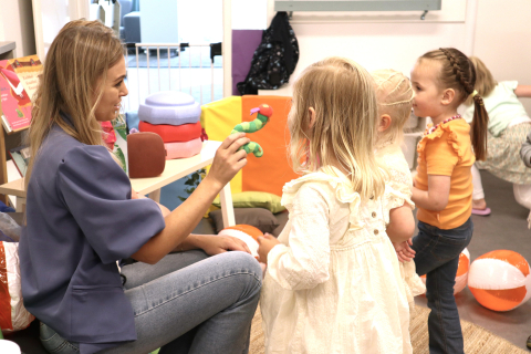 medewerker vertelt verhaal aan kinderen