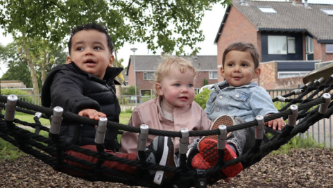 peuters zitten samen in de schommel