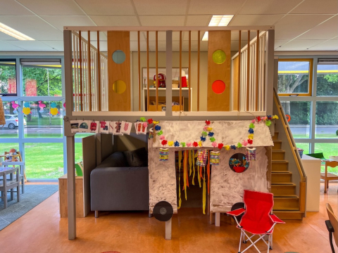 Binnenruimte van Peuterspeelgroep De Boevenhoeve in Opmeer. Een verhoogde speelzolder versierd met kleurrijke, papieren slingers.