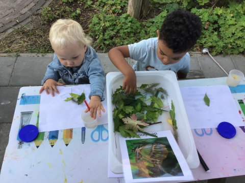 kinderen knutselen met bladeren van buiten