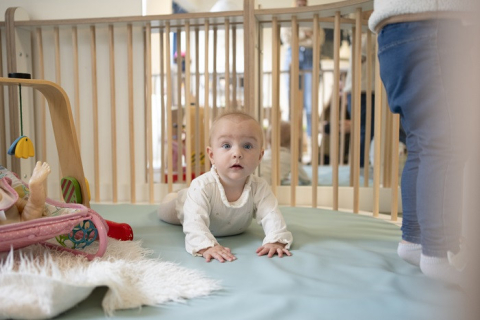 baby speelt in de grondbox