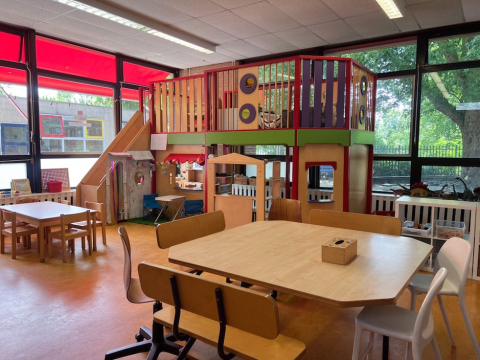 De BSO ruimte van De Boevenhoeve in Opmeer met grote ramen, groepstafels en een kleurrijke speelstructuur met glijbaan