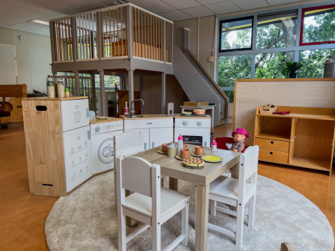 Speelruimte met speelgoedkeuken en houten speelhuisje bij kinderdagverblijf Boevenhoeve in Opmeer.