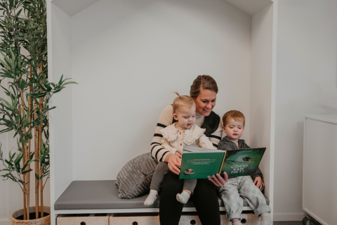 Pedagogisch professional leest een boek voor aan peuters