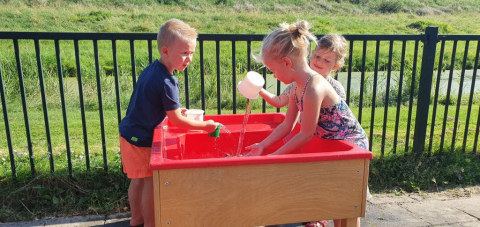 kinderen spelen buiten met watertafel