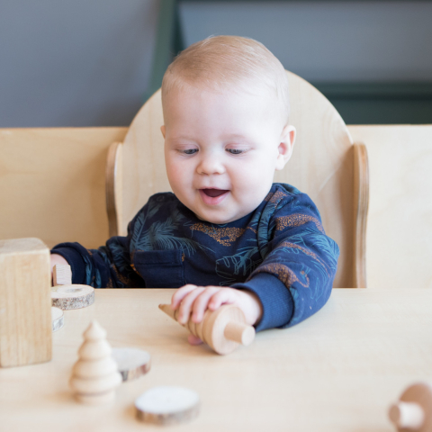 baby speelt met houten blokken