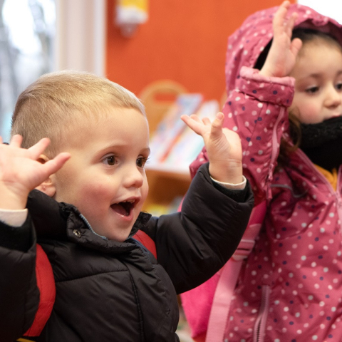 twee kinderen houden handen in lucht